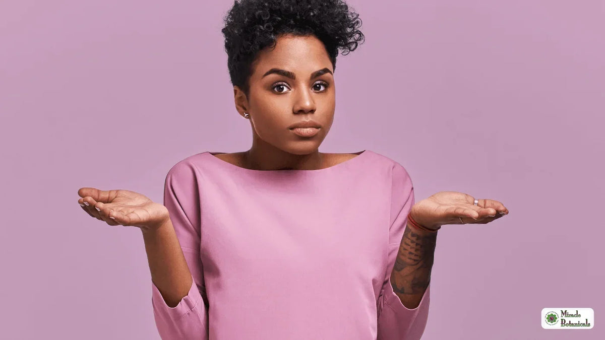 Woman in a pink top shrugging with both palms up and a puzzled expression against a lilac background