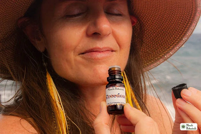 Woman smelling a Miracle Botanicals 100% pure essential oil blend outdoors