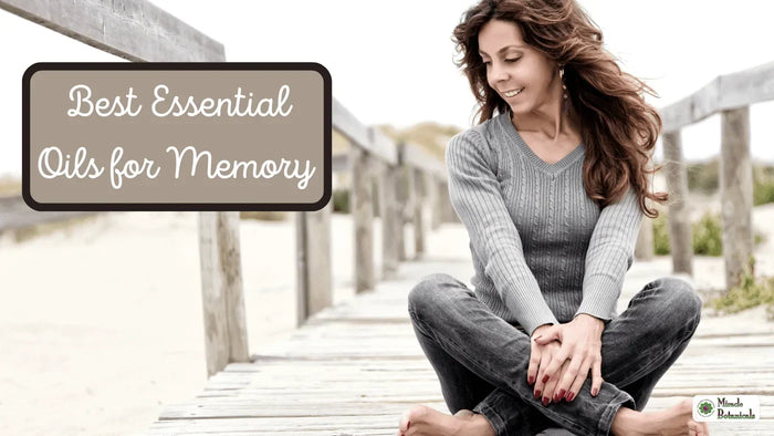 Smiling woman sitting cross-legged on a wooden beach boardwalk, with text: Best Essential Oils for Memory