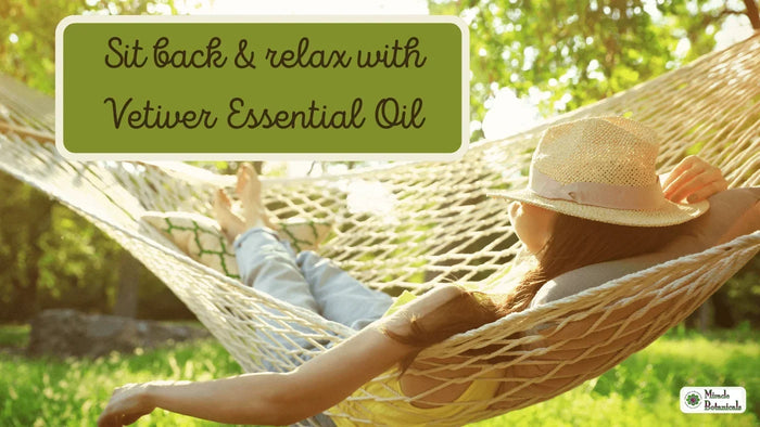 Woman in a straw hat relaxing in a hammock under sunlit trees, with text: Sit back & relax with Vetiver Essential Oil