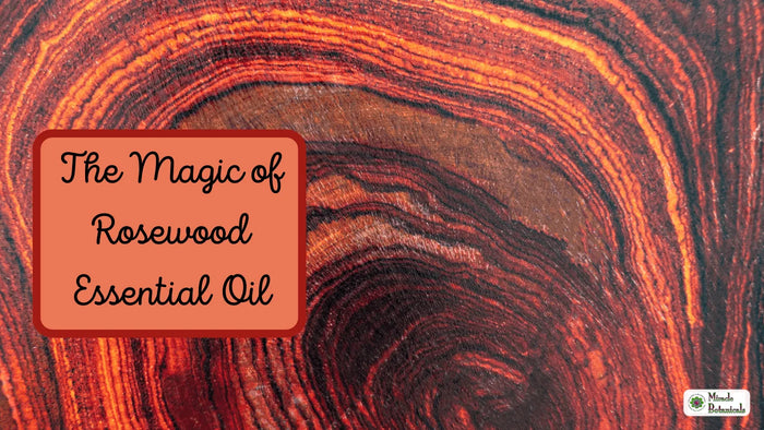 Swirling red and orange wood grain, with text: The Magic of Rosewood Essential Oil
